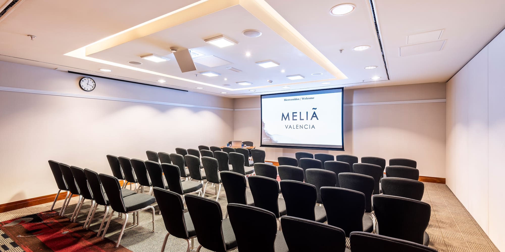 a room with rows of chairs and a projector screen