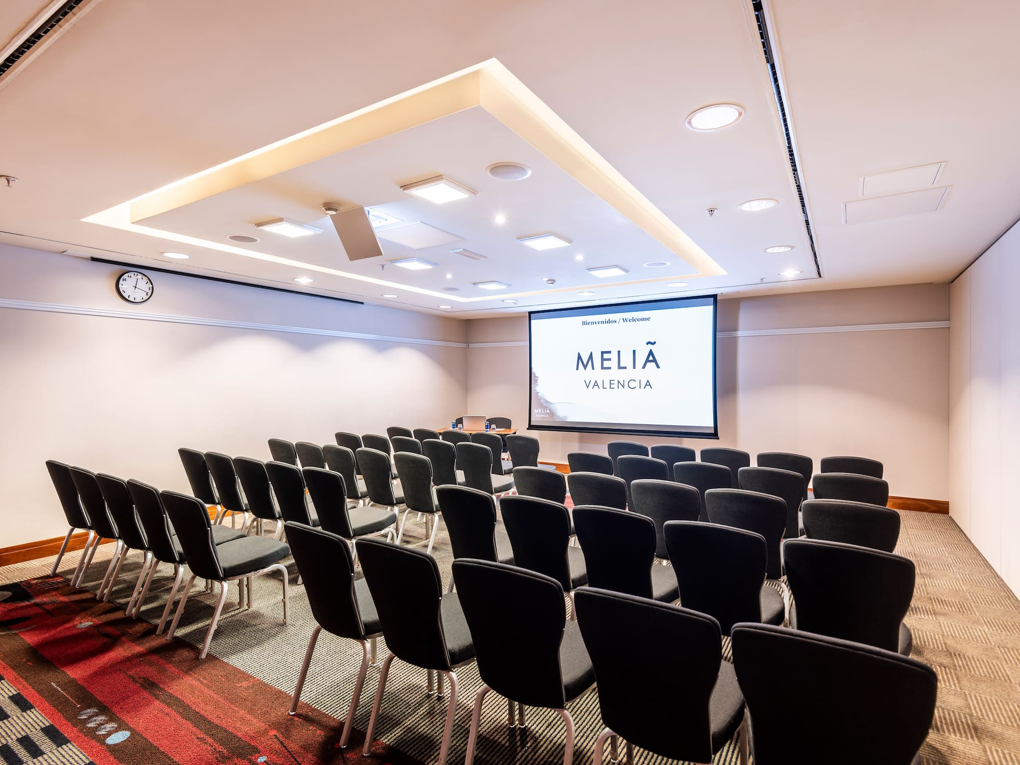 a room with rows of chairs and a projector screen