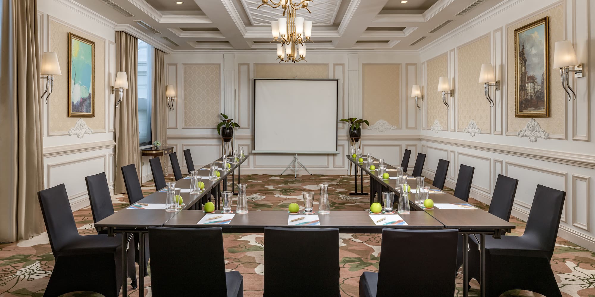 a room with a large screen and tables