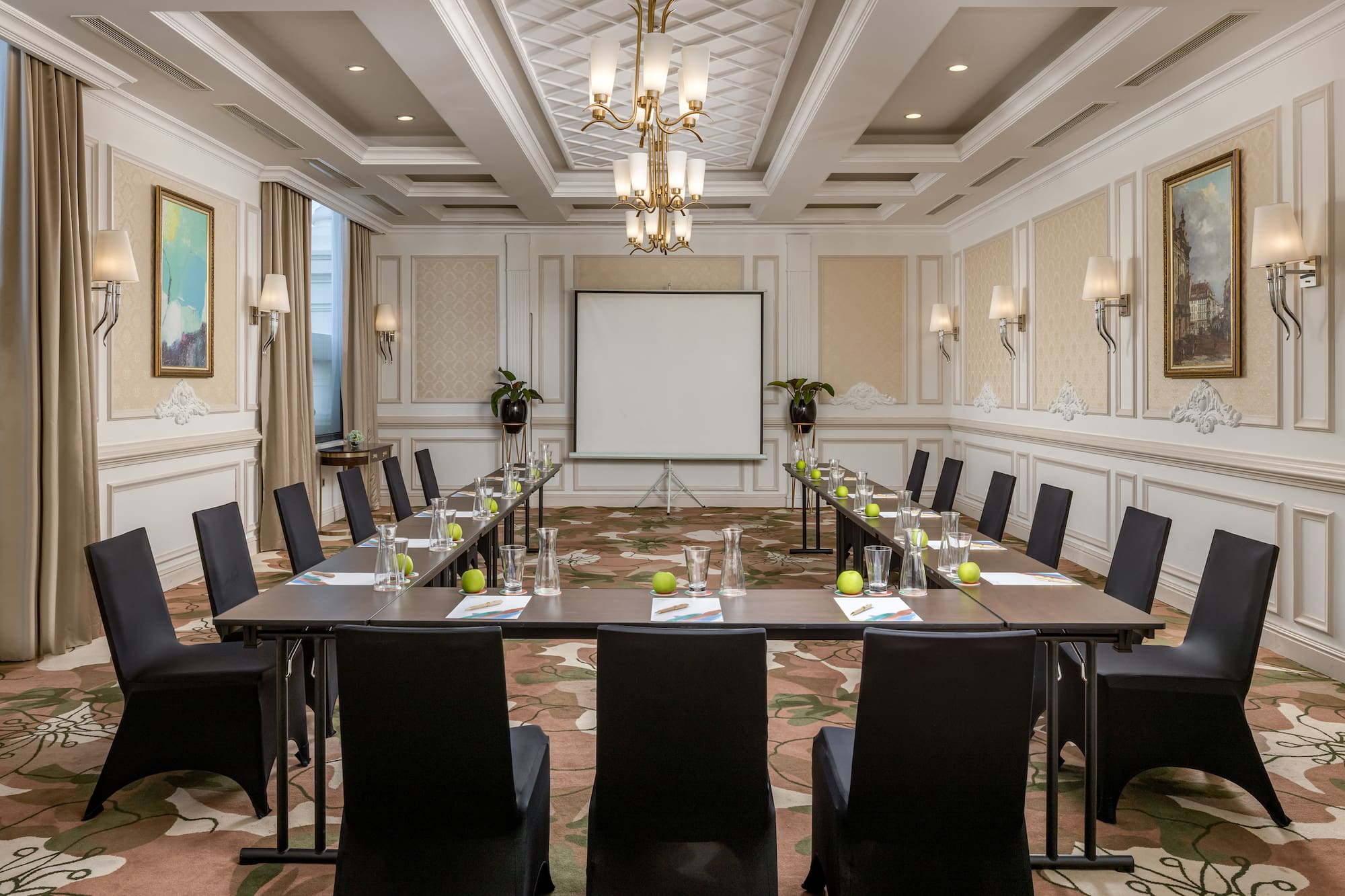 a room with a large screen and tables