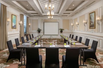 a room with a large screen and tables