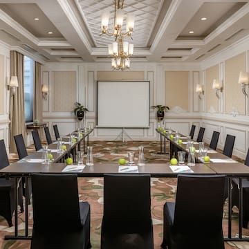 a room with a large screen and tables