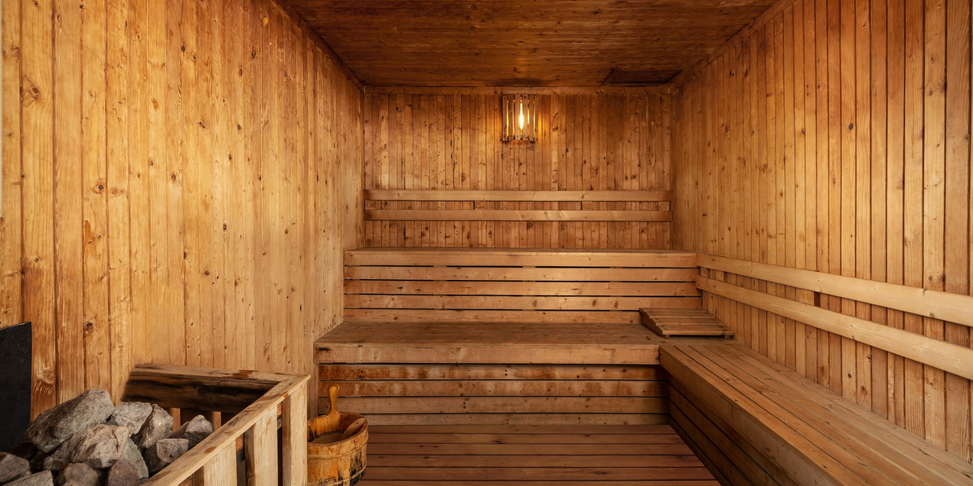 a wooden sauna with a bucket and a bucket of rocks