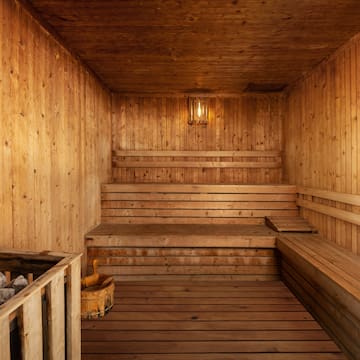 a wooden sauna with a bucket and a bucket of rocks