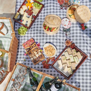 a picnic blanket with food and drinks