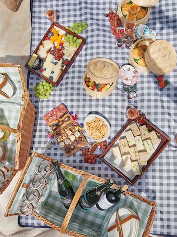 a picnic blanket with food and drinks