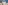 Ornate beige historic building with grand tower, framed by flanking modern structures.