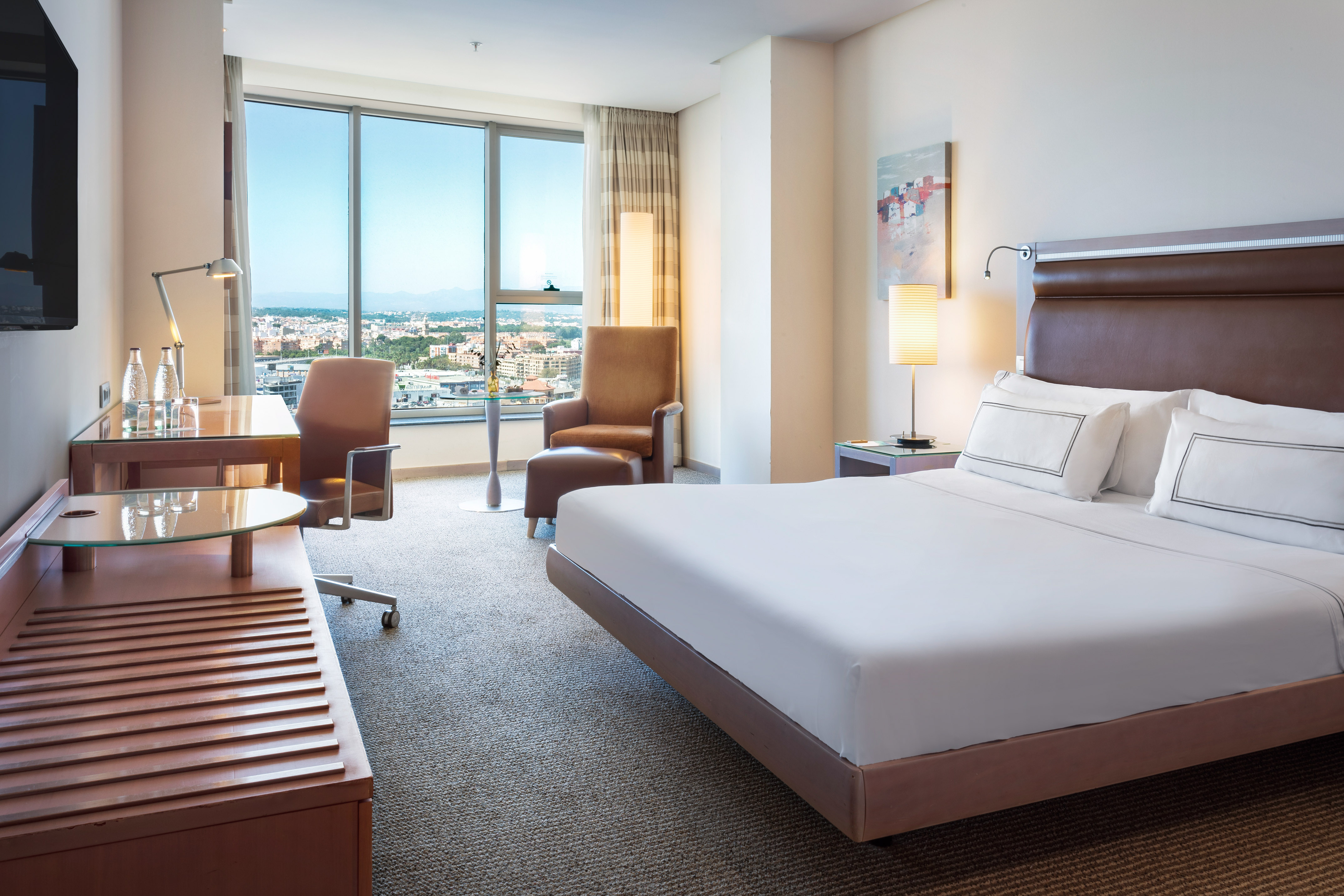 a hotel room with a bed and a desk and chairs