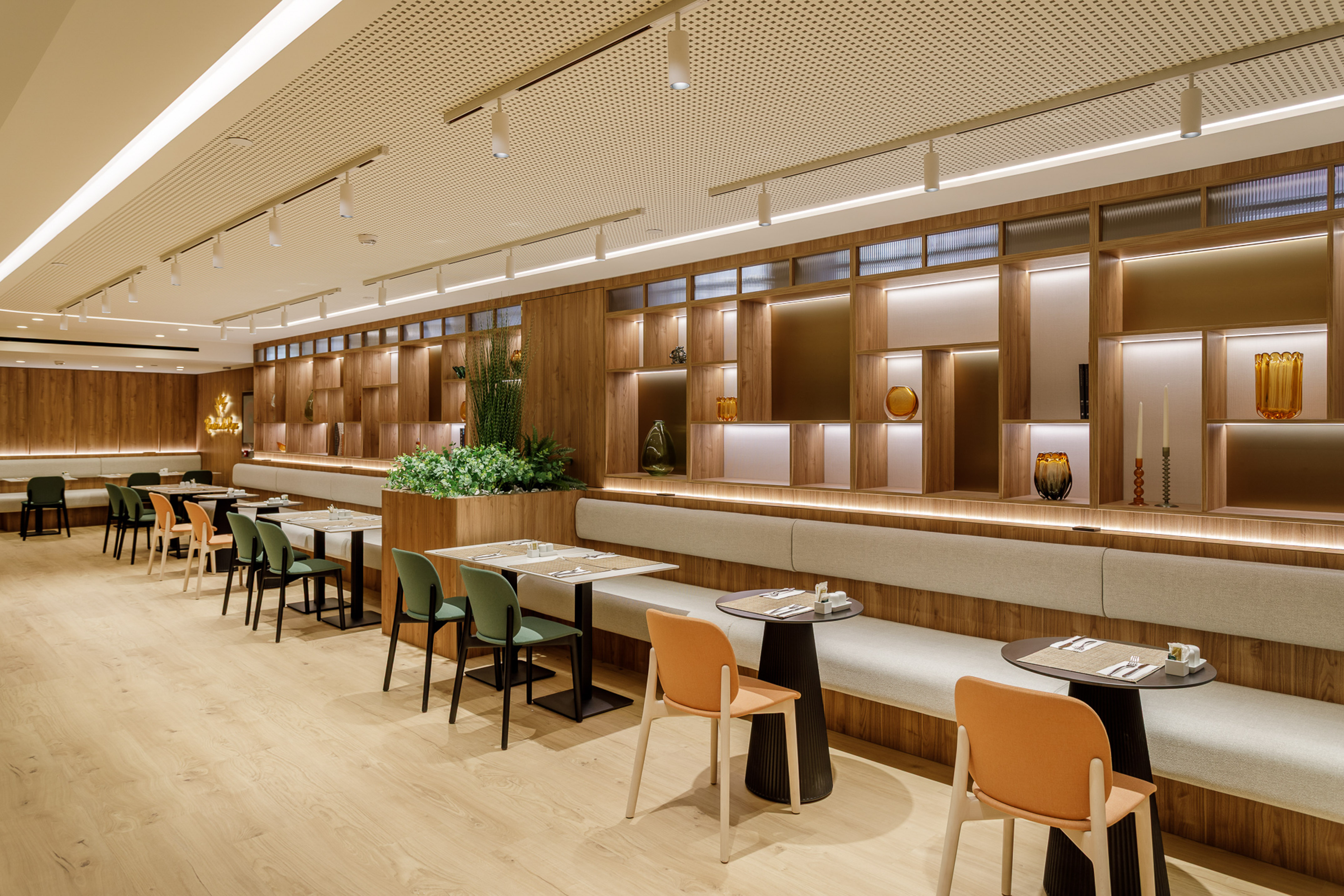 Contemporary restaurant with wooden interior, banquette seating, and stylish lighting.
