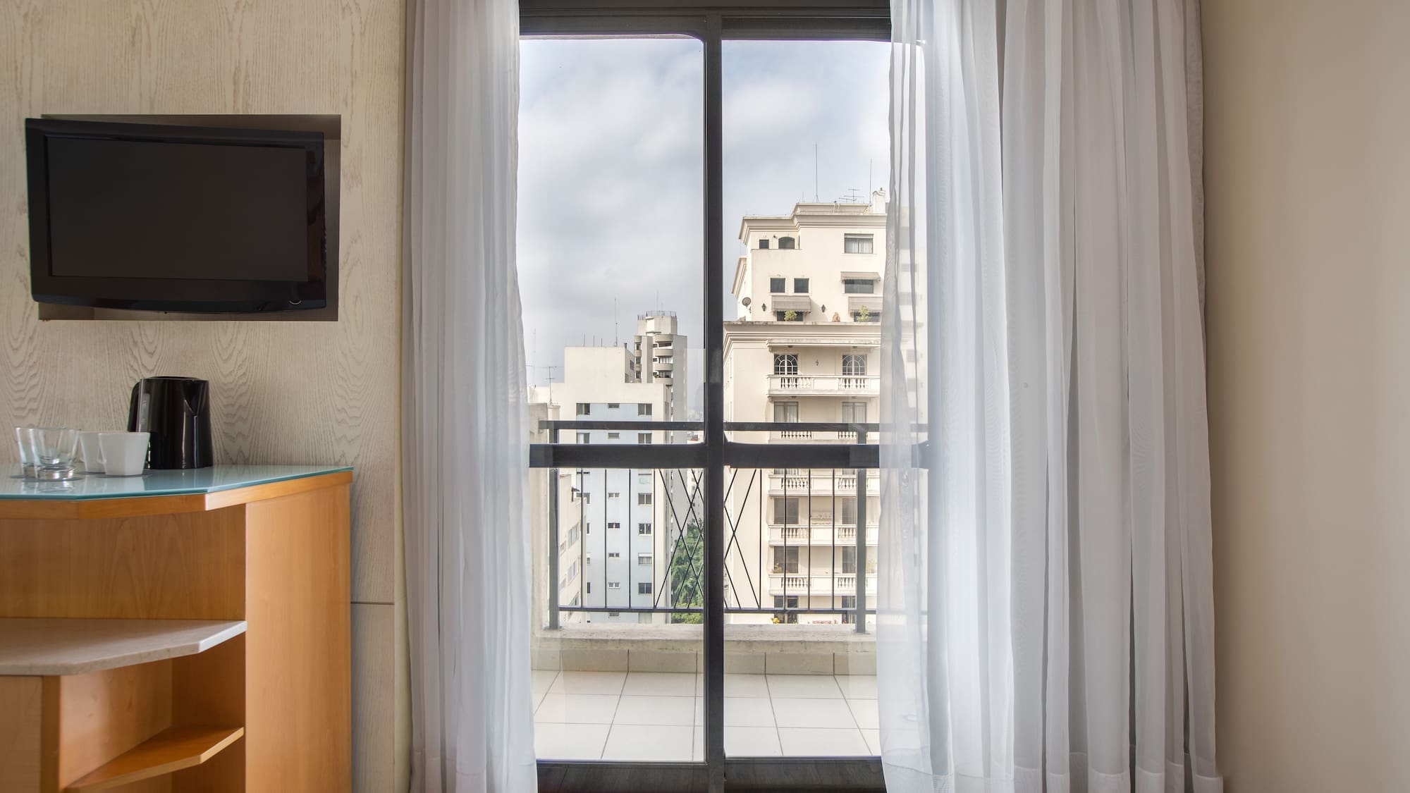 a room with a balcony and a television