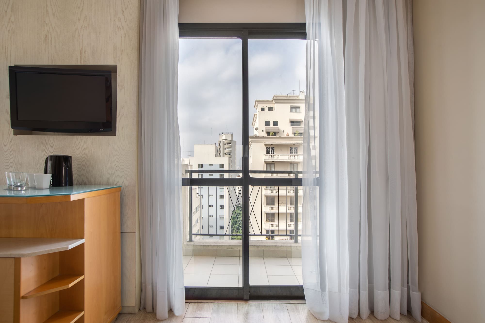 a room with a balcony and a television