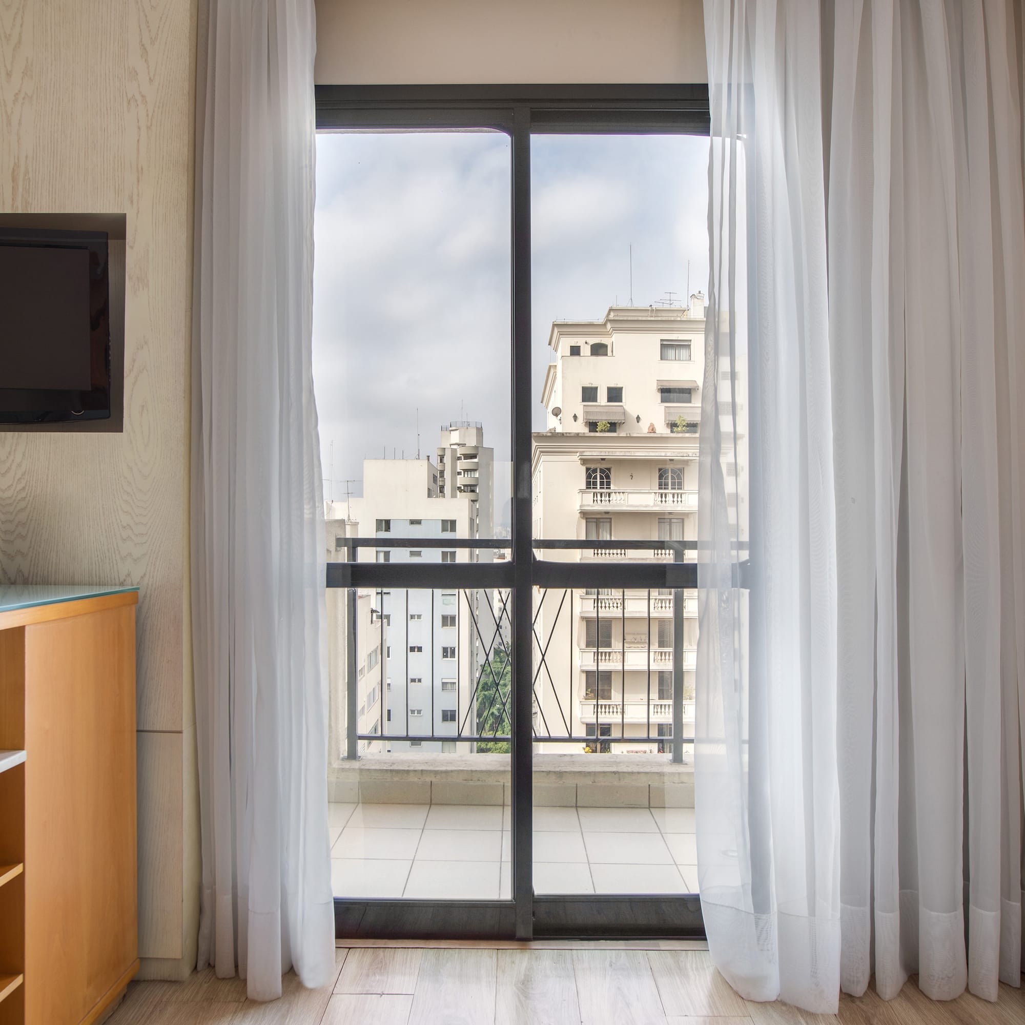 a room with a balcony and a television