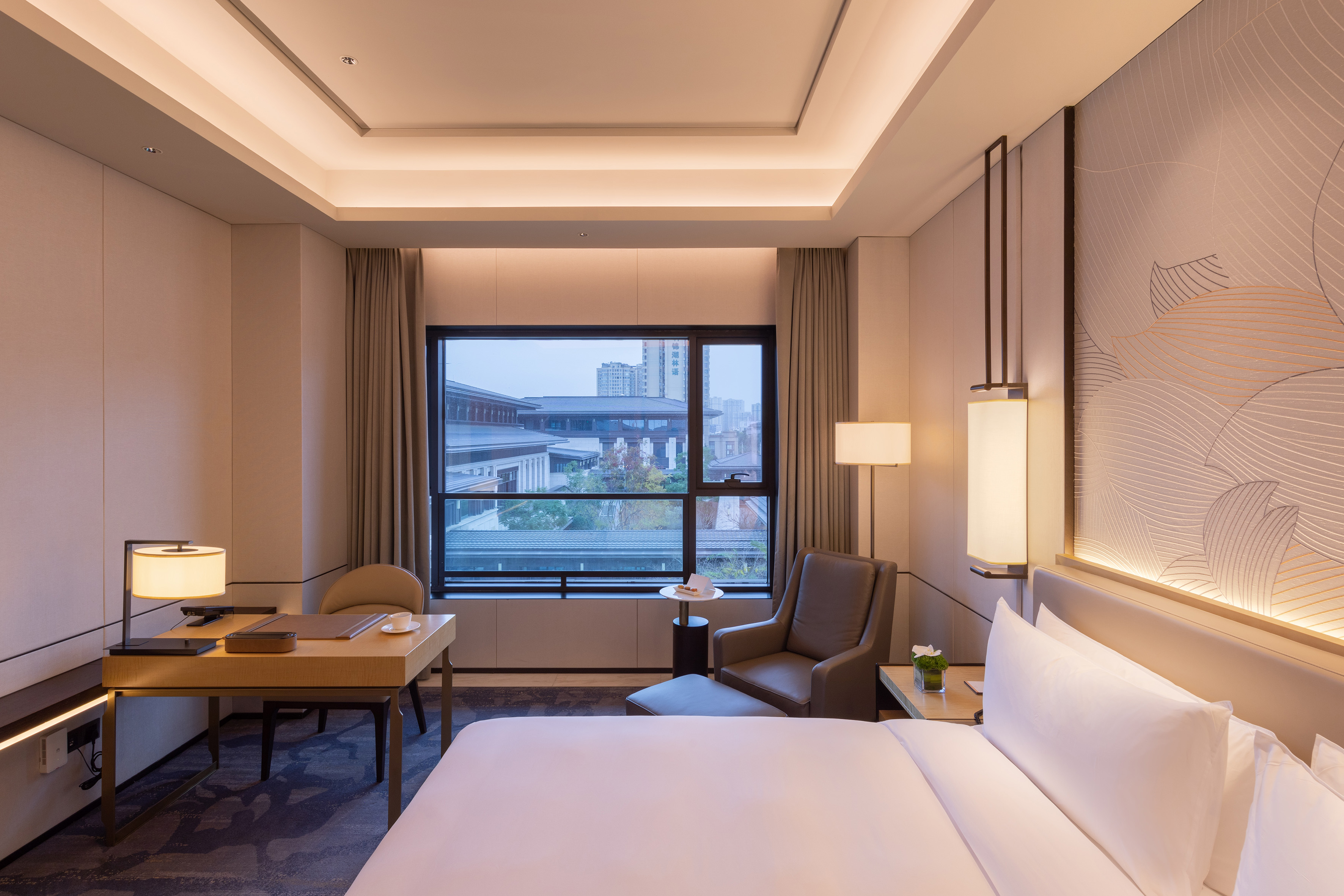 Luxury hotel room with modern decor, king bed, work desk, and window view.