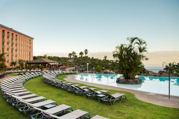 a pool with lounge chairs and palm trees