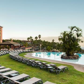 a pool with lounge chairs and palm trees