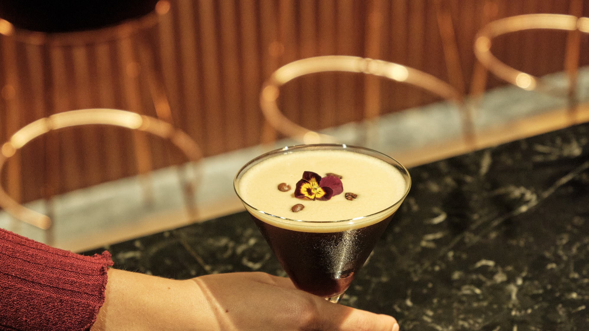 a hand holding a glass of liquid