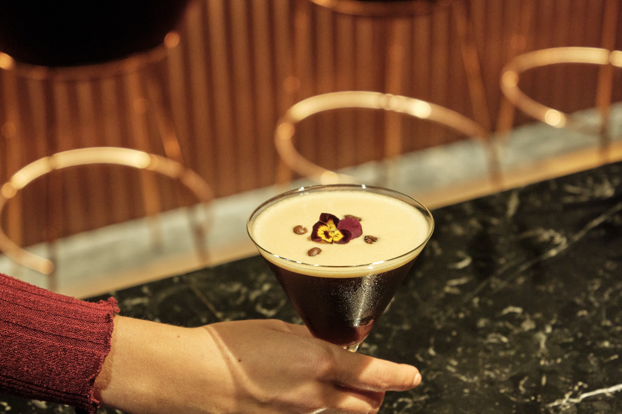 a hand holding a glass of liquid