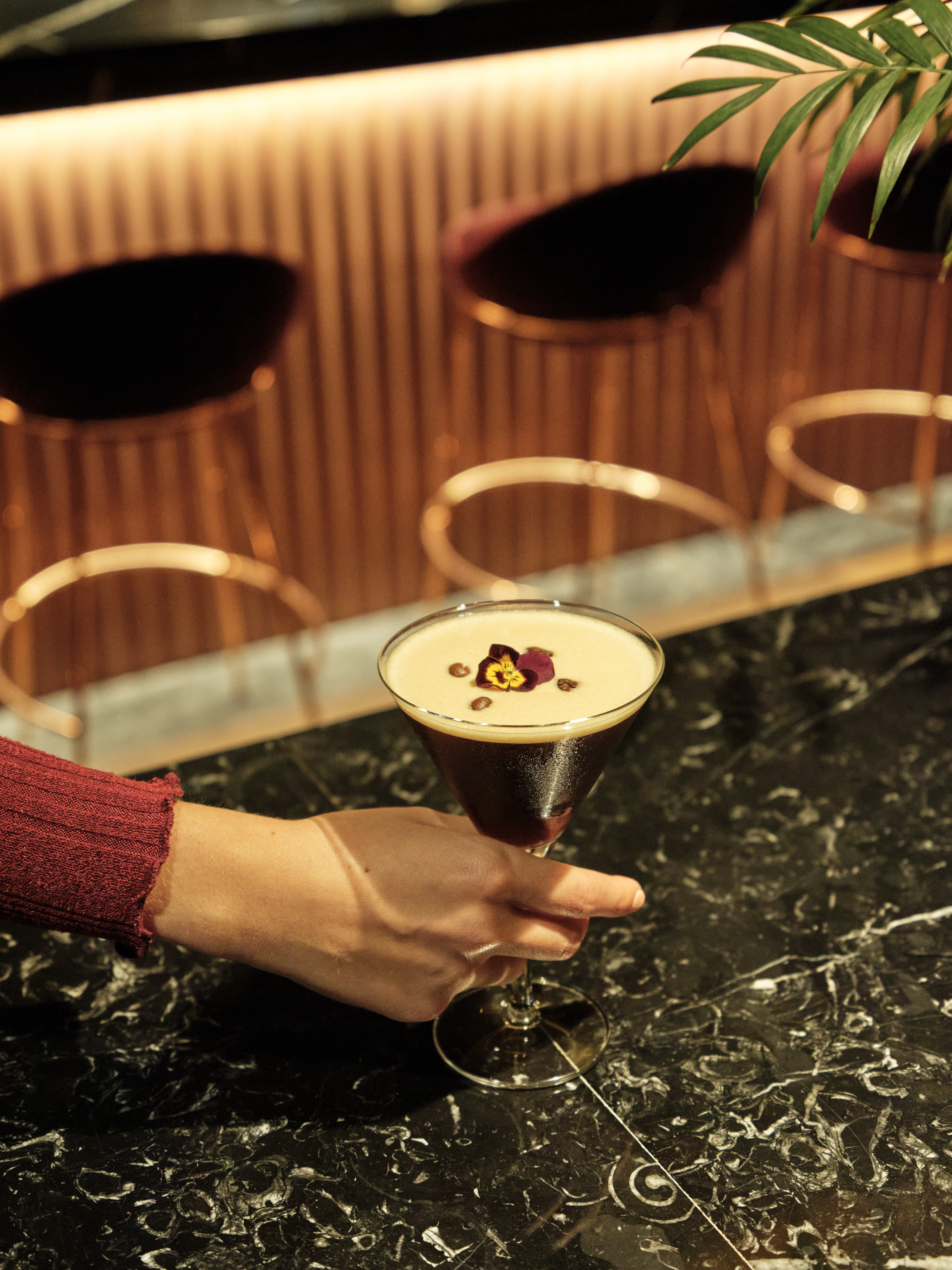 a hand holding a glass of liquid