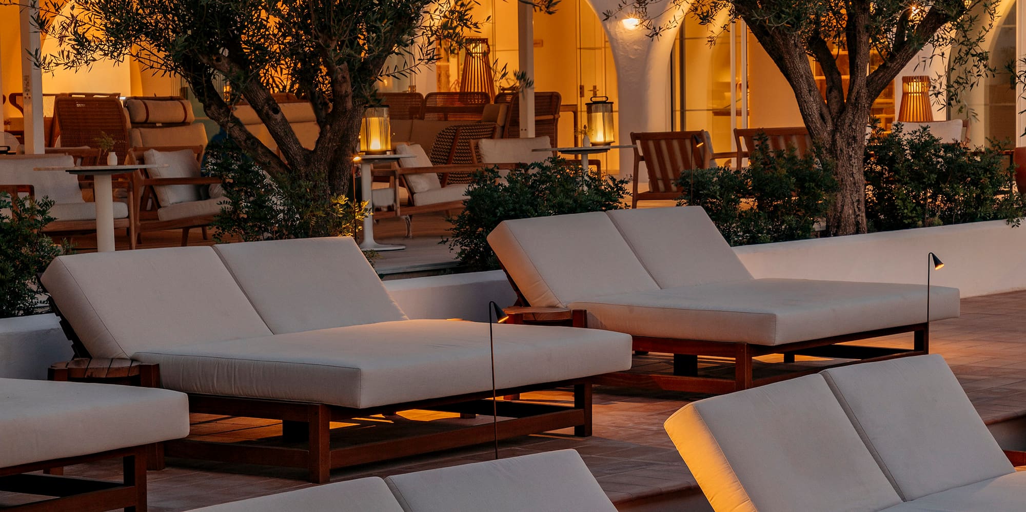a group of white lounge chairs outside of a building