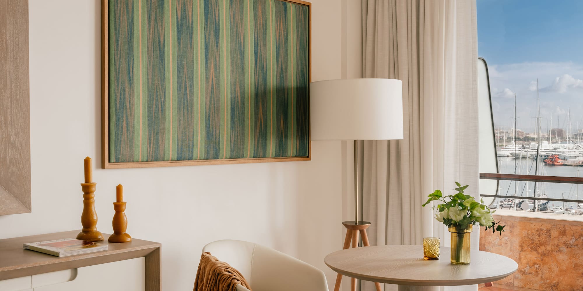 a room with a table and chairs and a painting on the wall