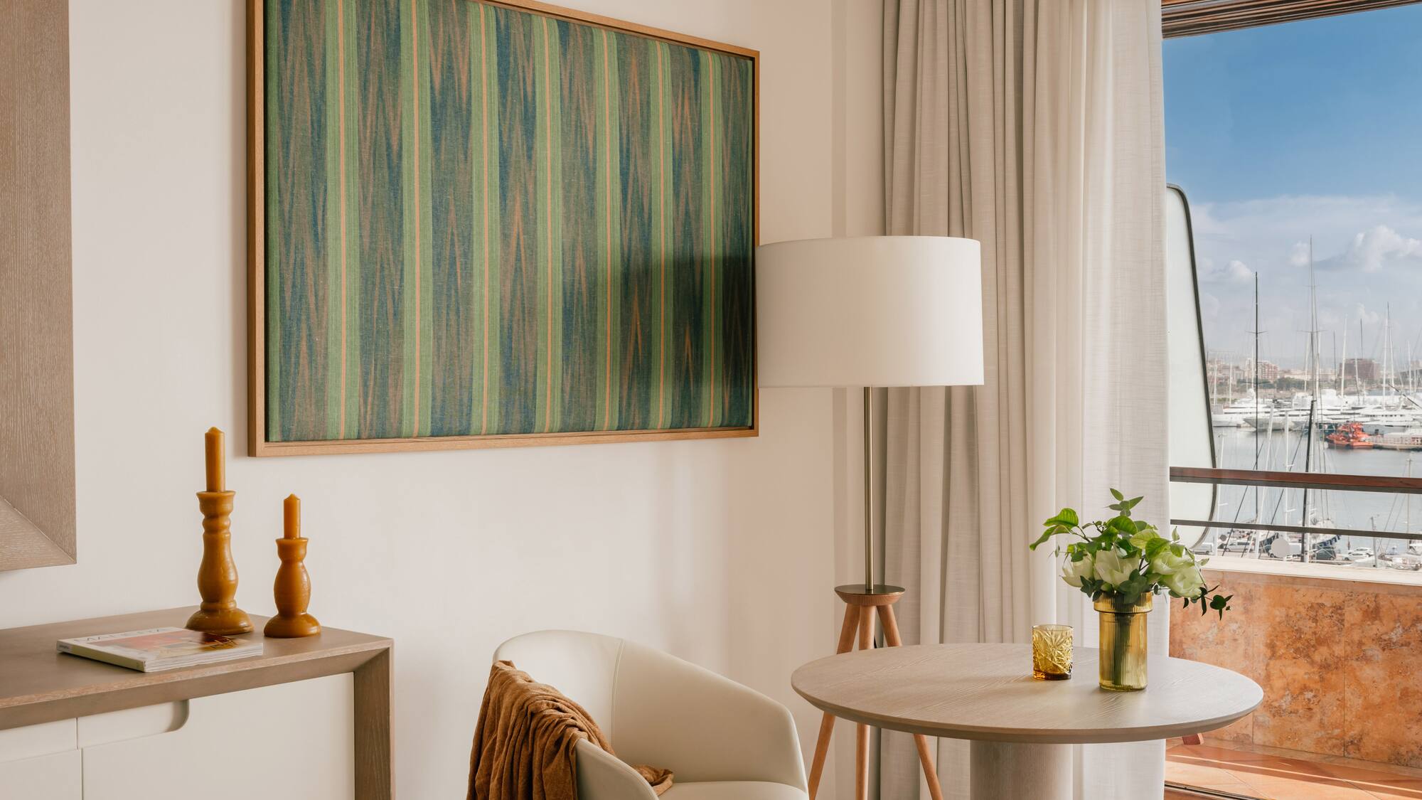 a room with a table and chairs and a painting on the wall