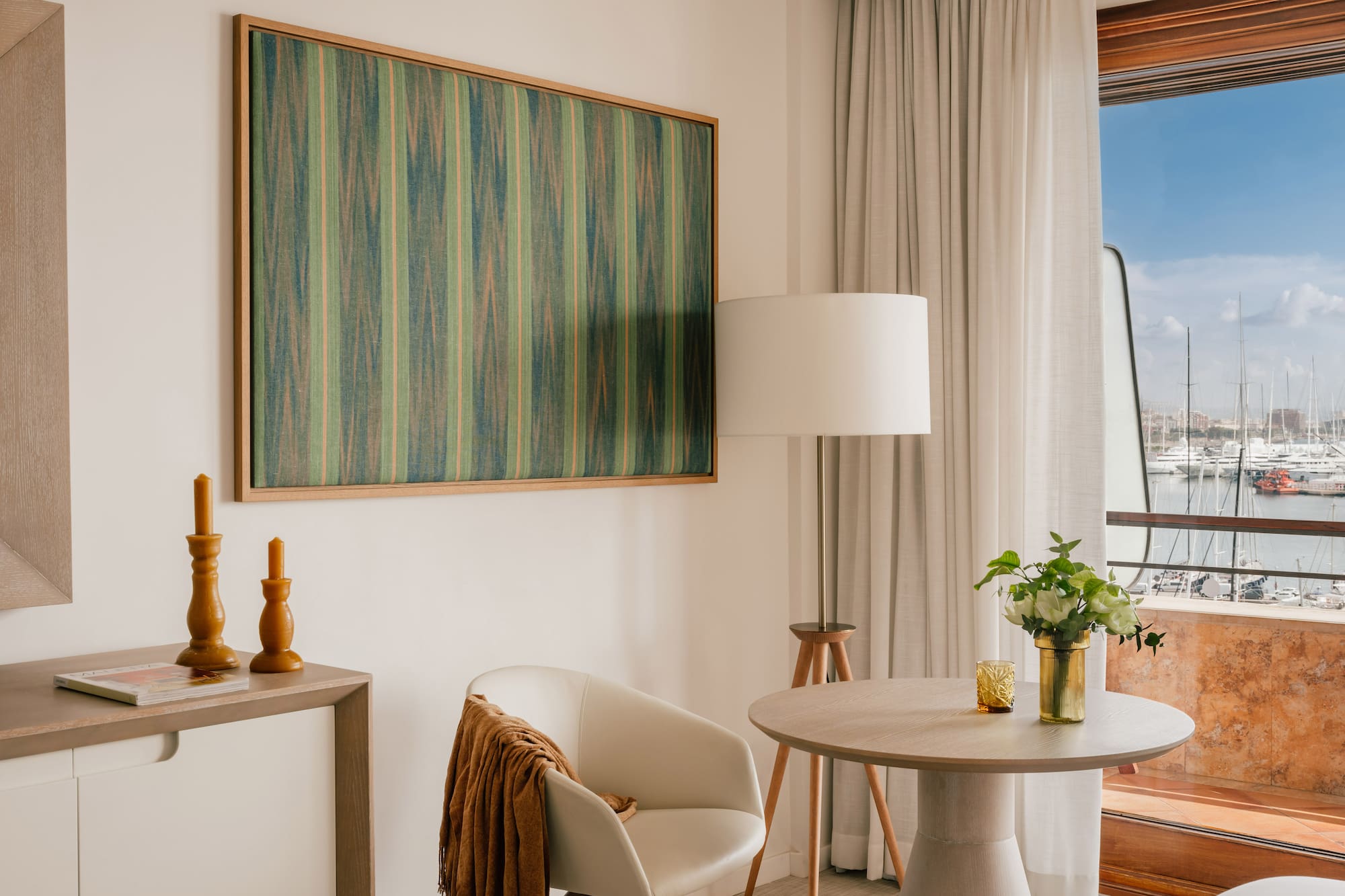 a room with a table and chairs and a painting on the wall