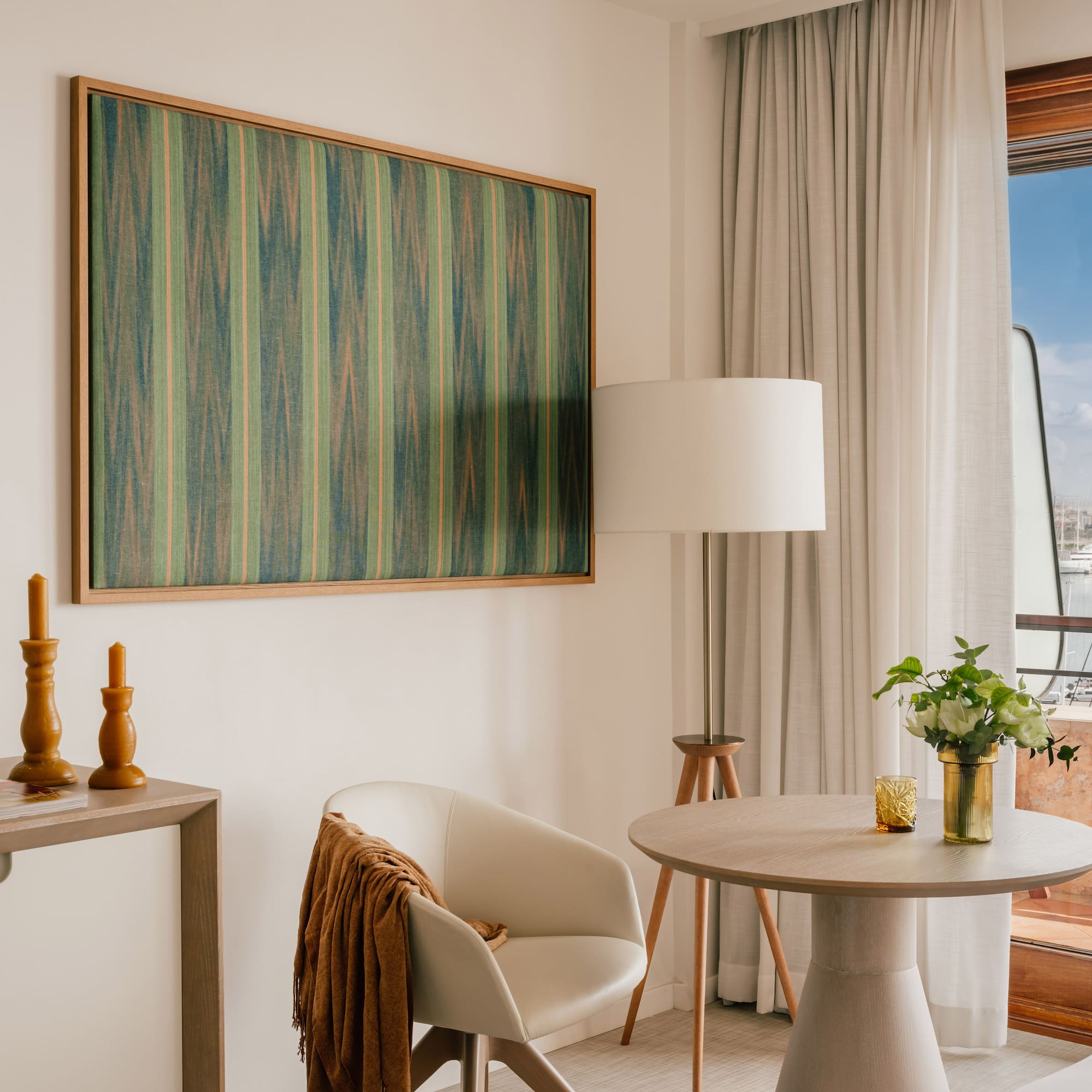 a room with a table and chairs and a painting on the wall