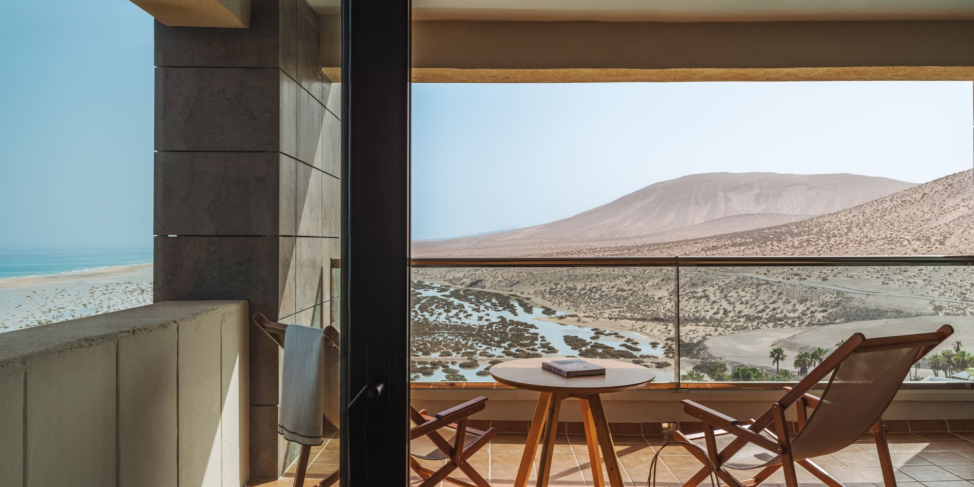 a balcony with chairs and a table