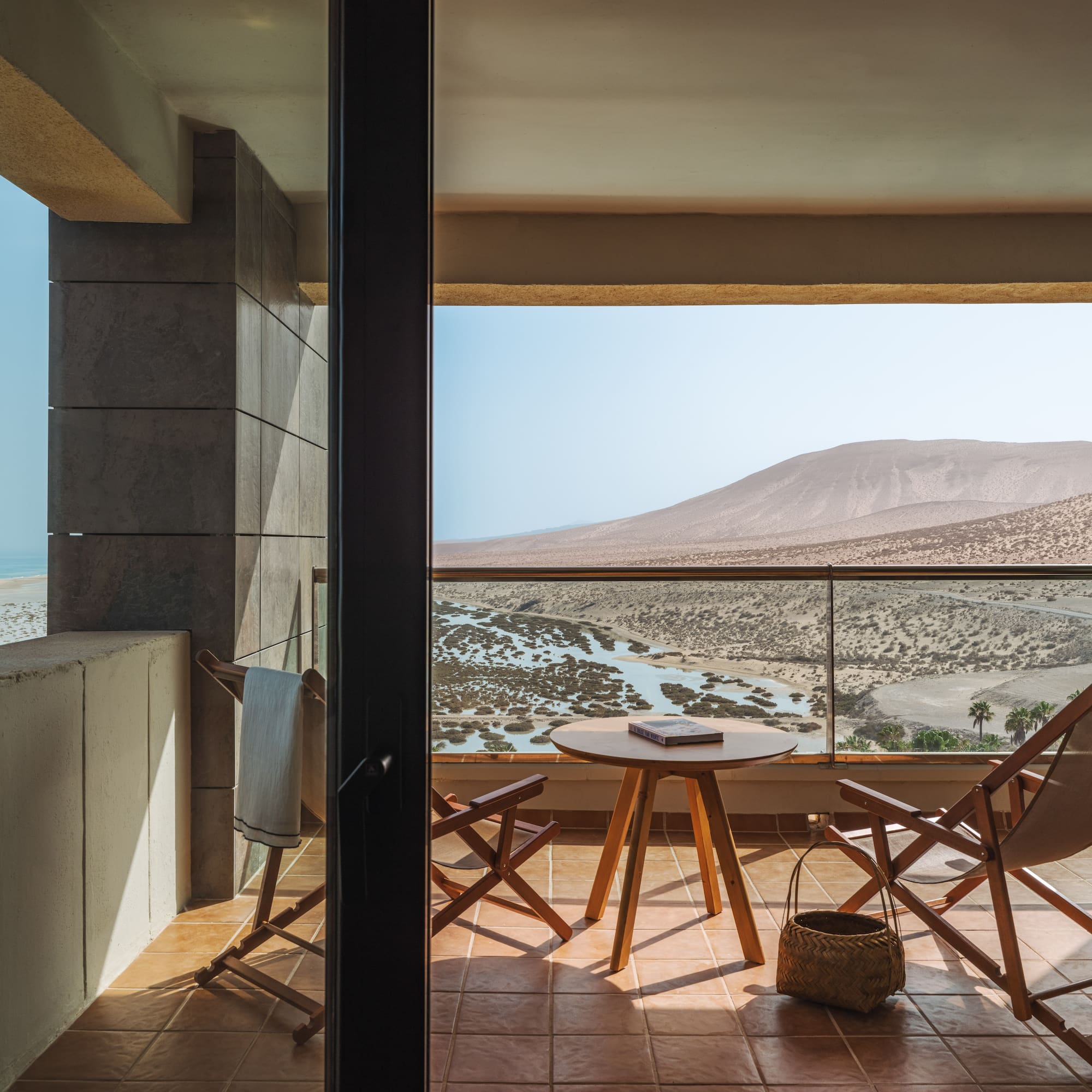 a balcony with chairs and a table