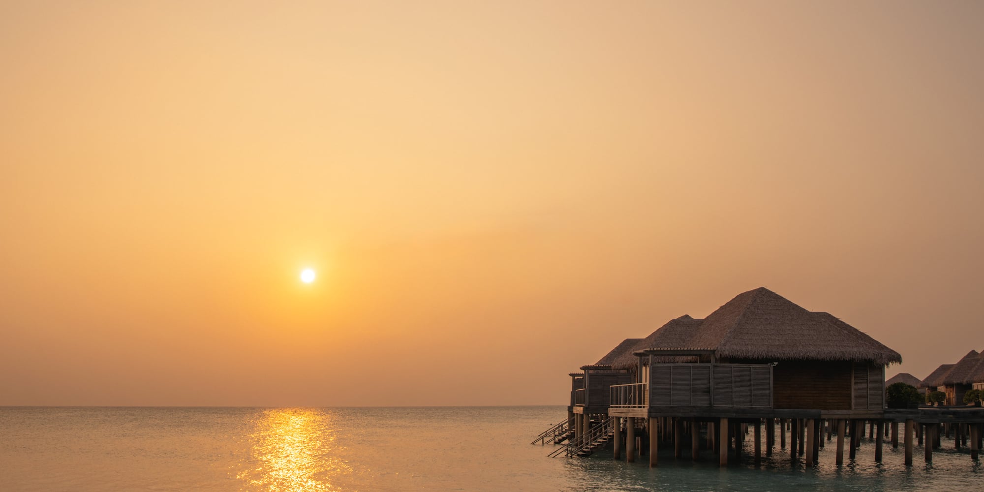 a group of huts on stilts on water
