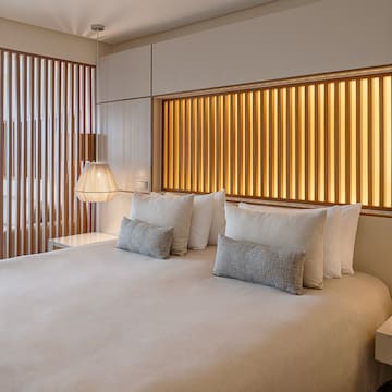 a bed with pillows and lamps in a room