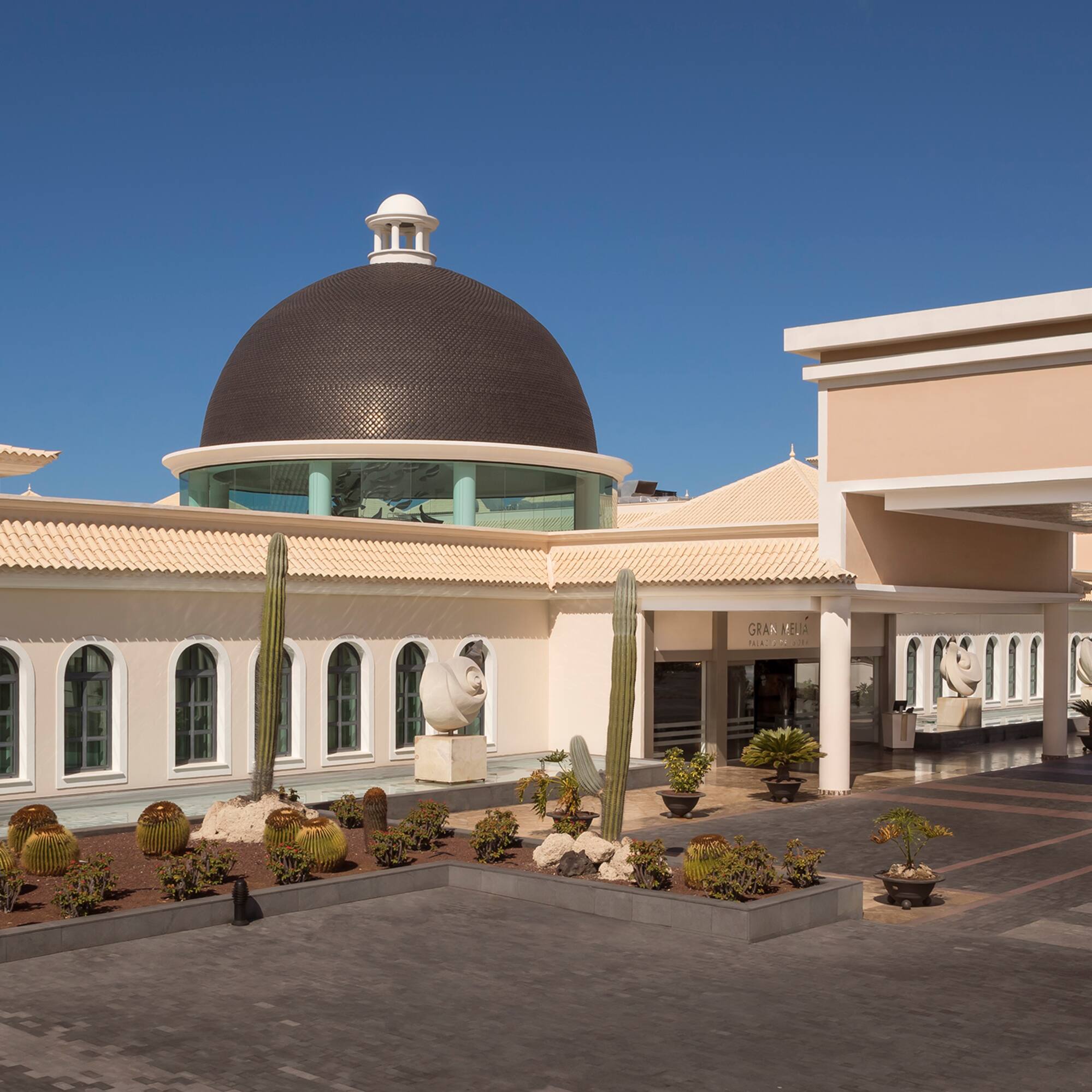 a building with a dome and cactus plants