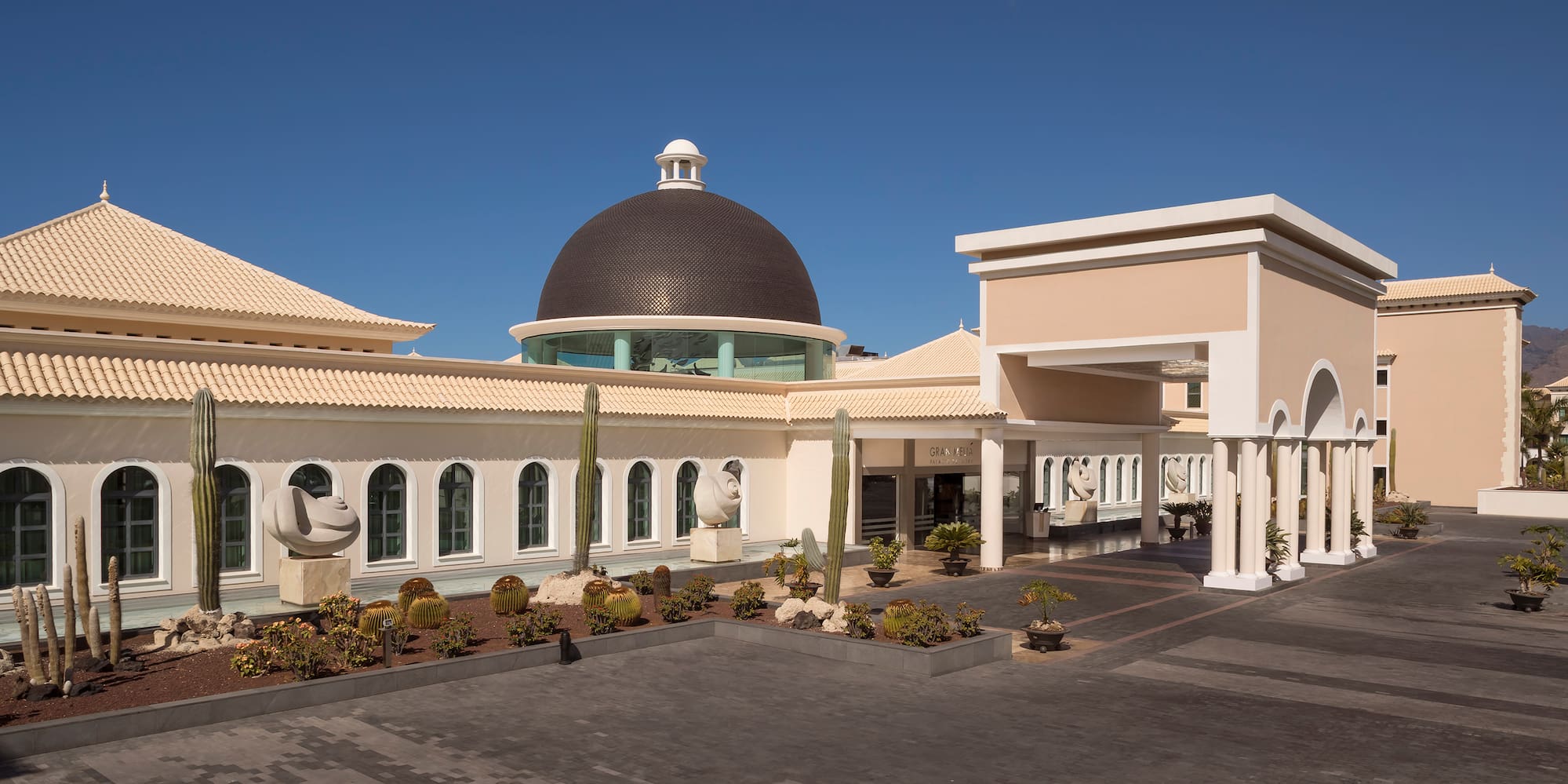a building with a dome and cactus plants