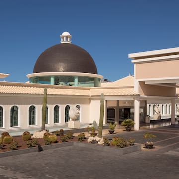 a building with a dome and cactus plants