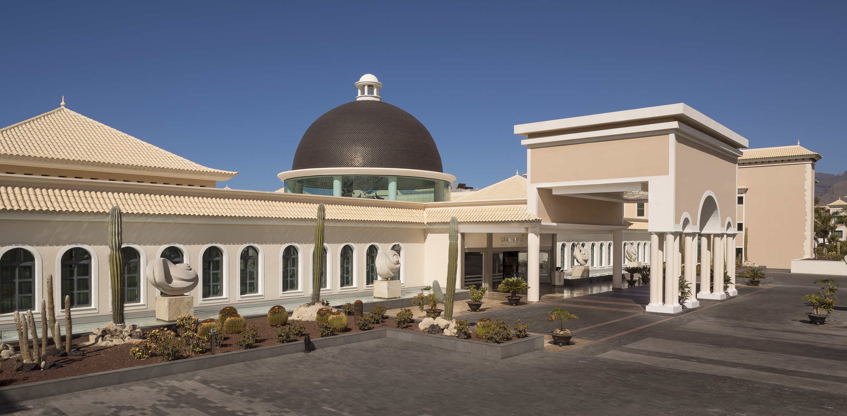 a building with a dome and cactus plants