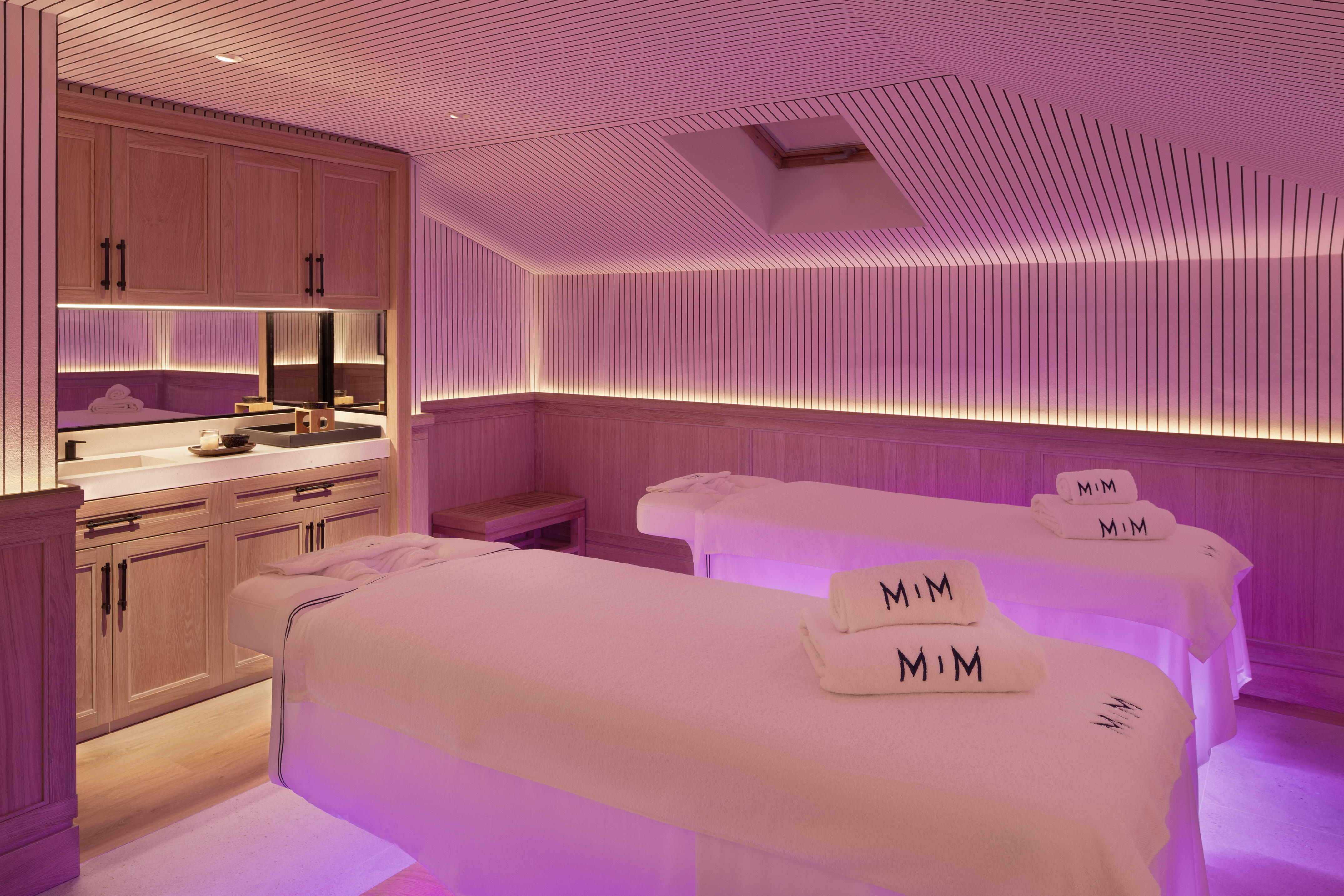 a room with beds and purple lighting