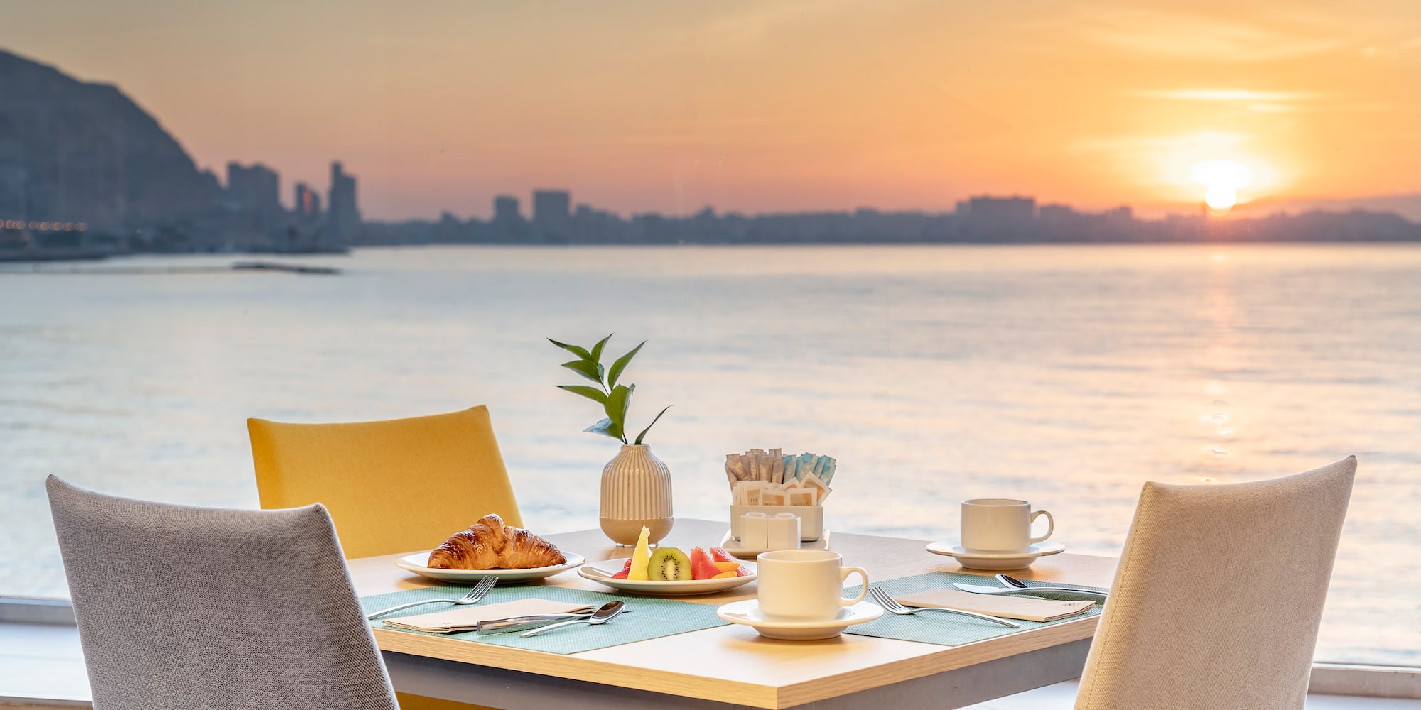 a table with food on it and a view of the water