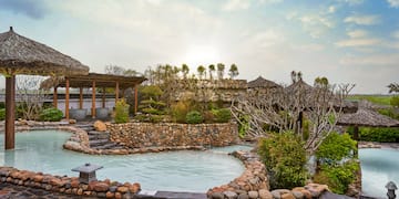 a pool with a stone wall and a stone structure