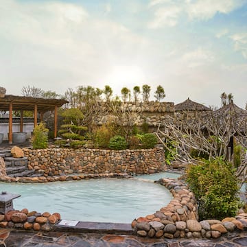 a pool with a stone wall and a stone structure