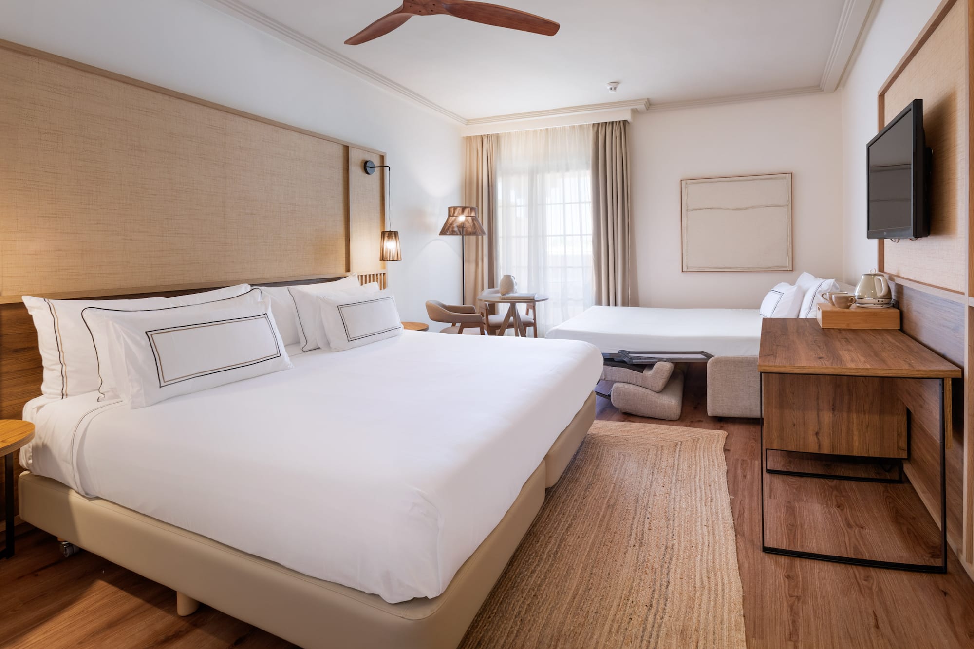 a room with two beds and a fan