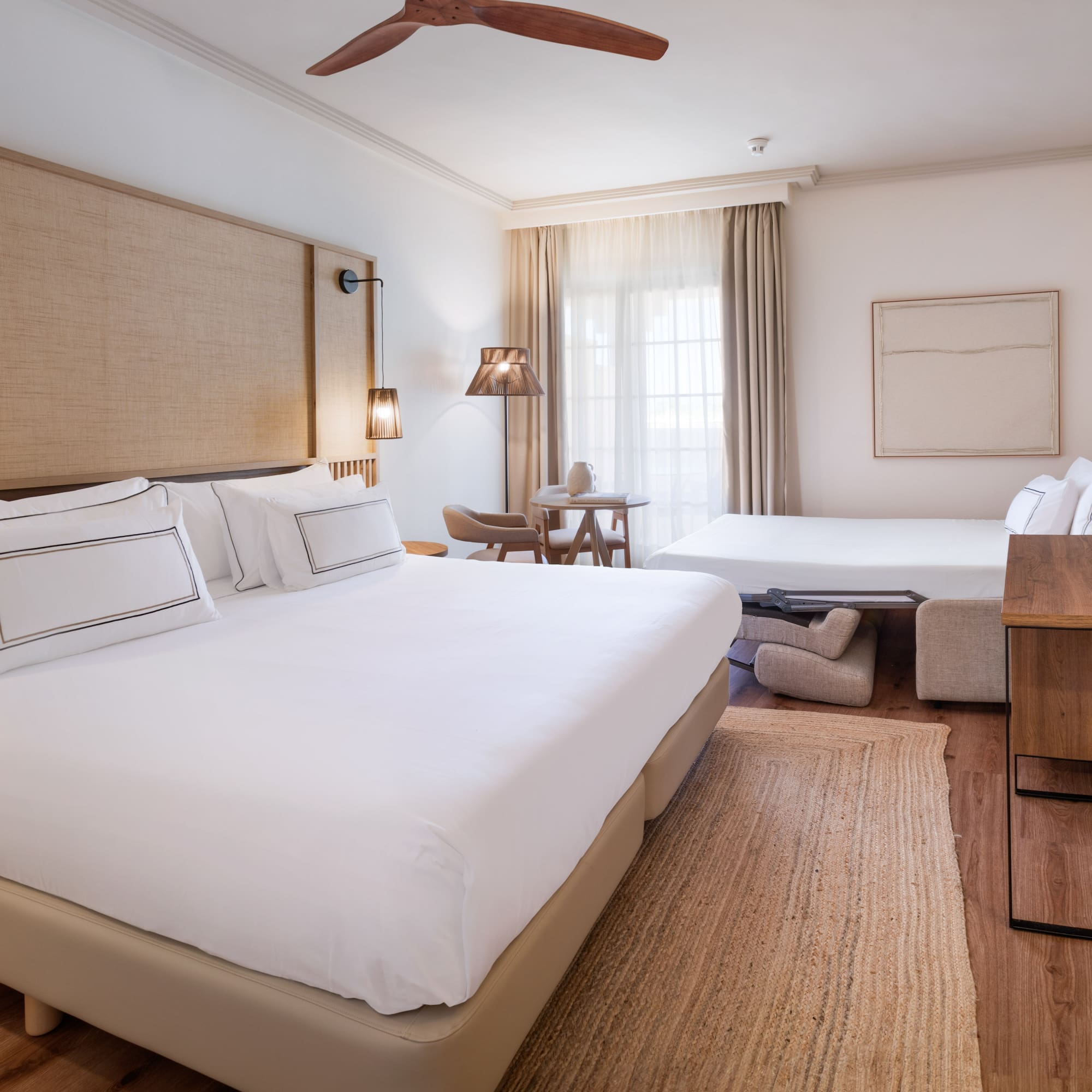 a room with two beds and a fan