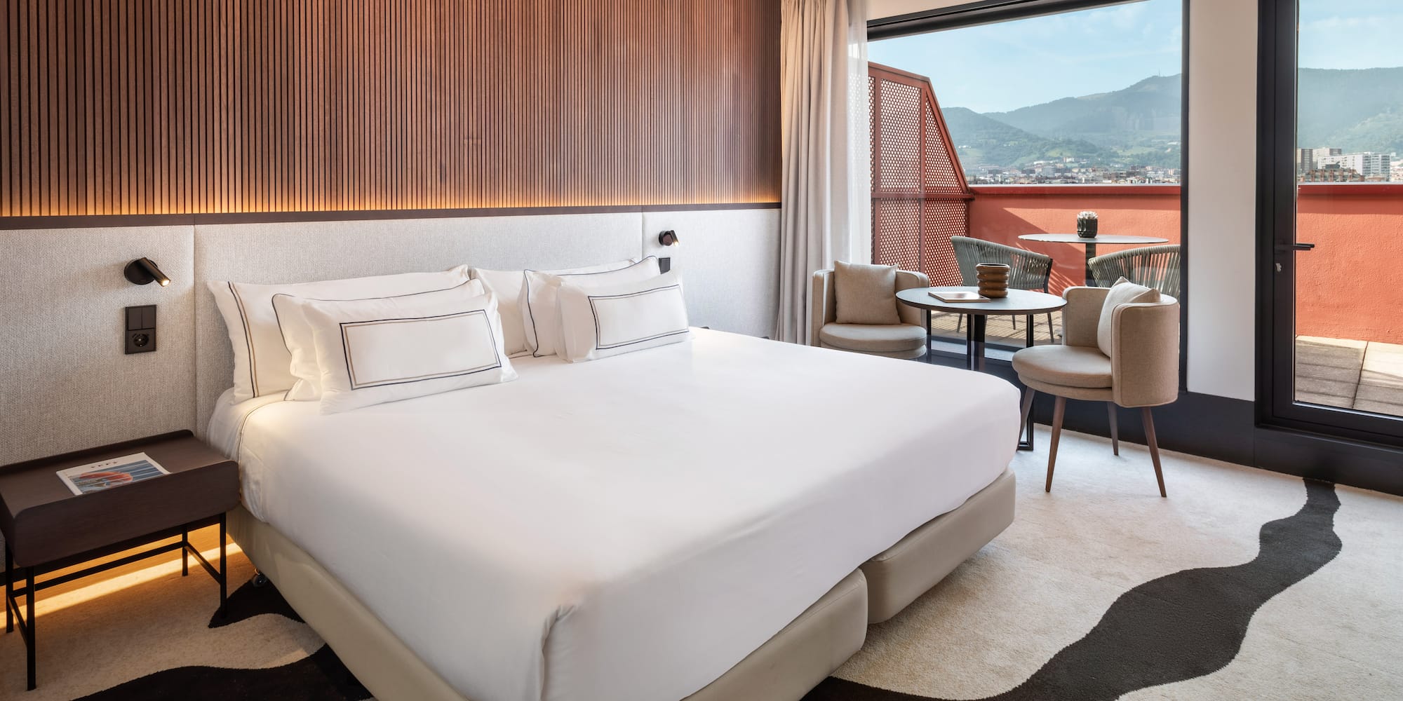 a room with a bed and chairs and a table