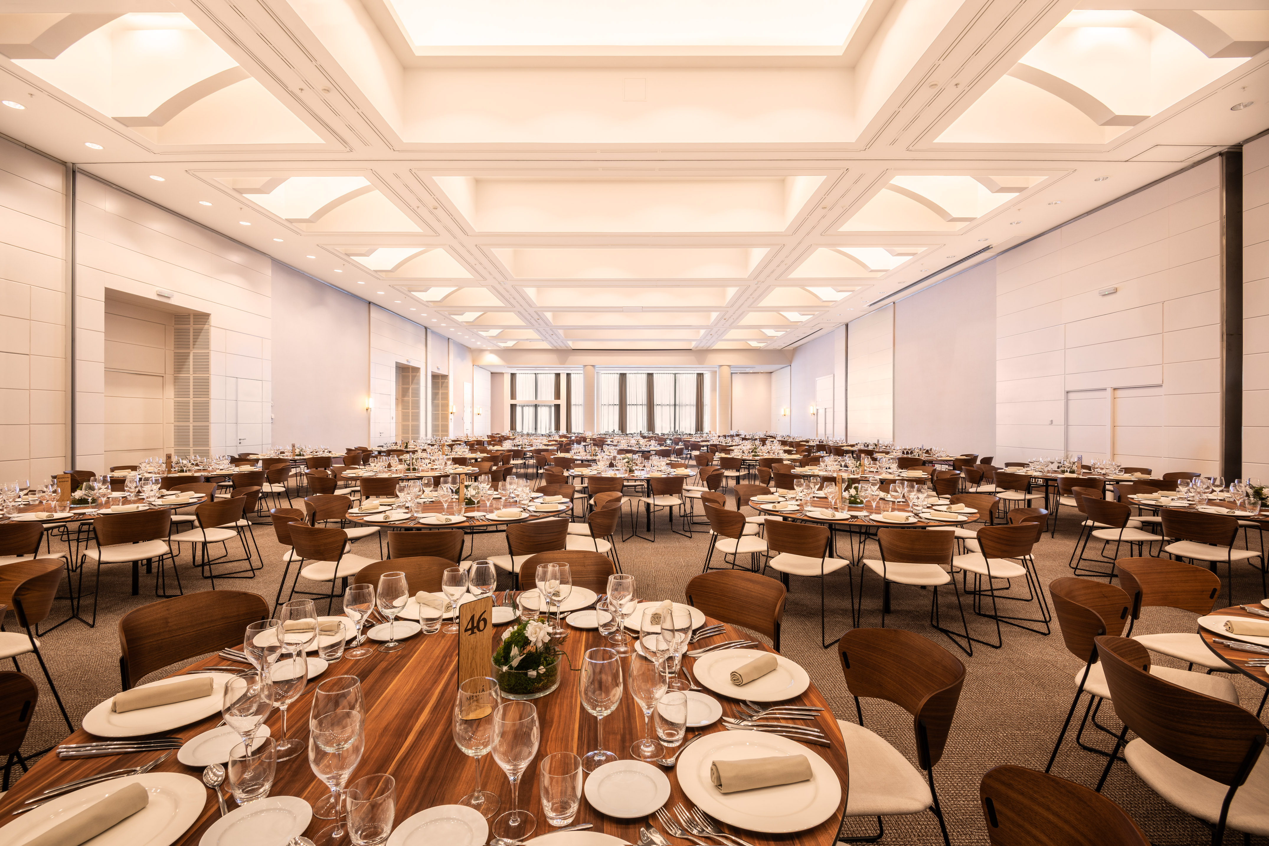 Spacious banquet hall with numerous round tables set for a large event.