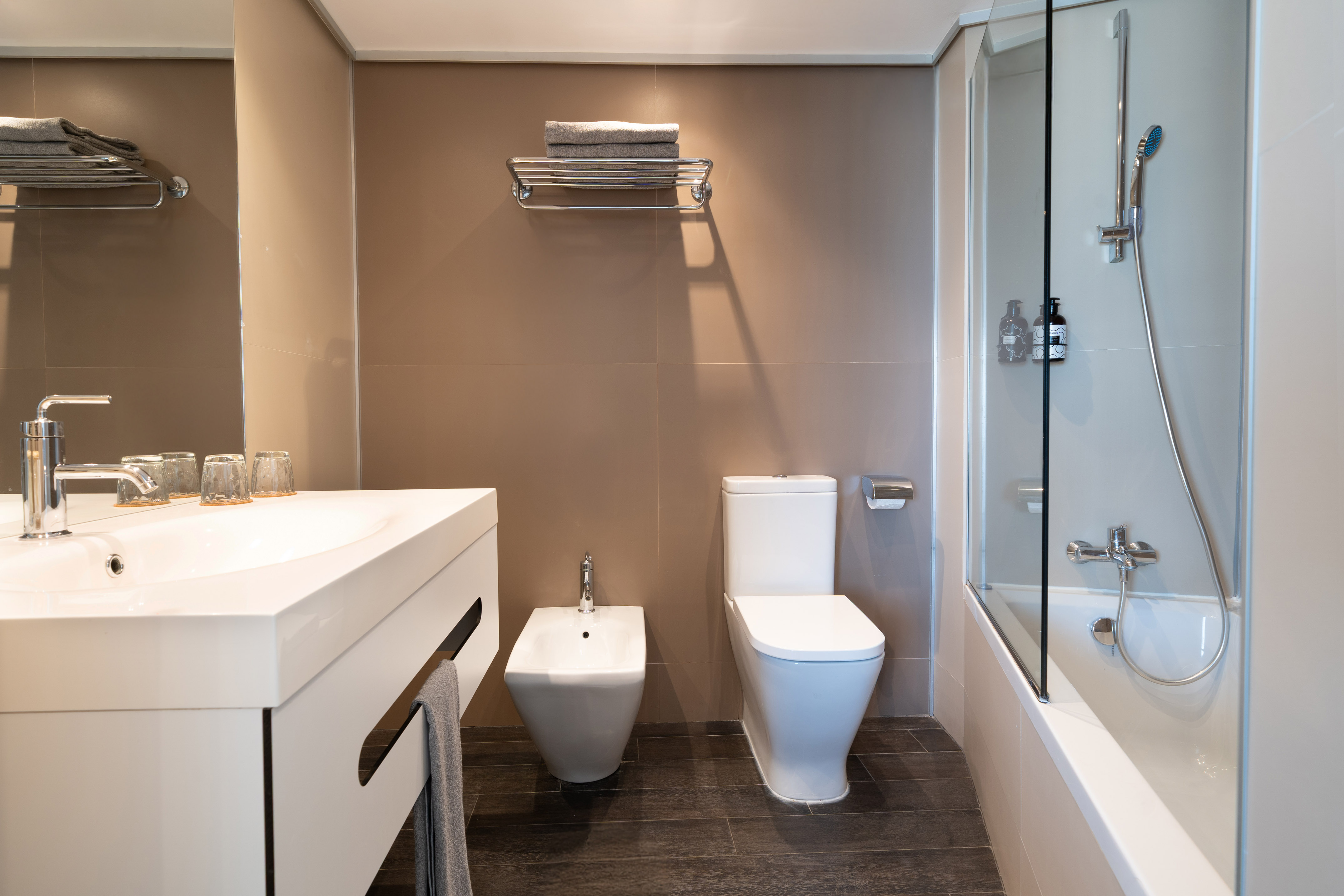 Contemporary hotel bathroom interior with sink, toilet, bidet, shower-tub.
