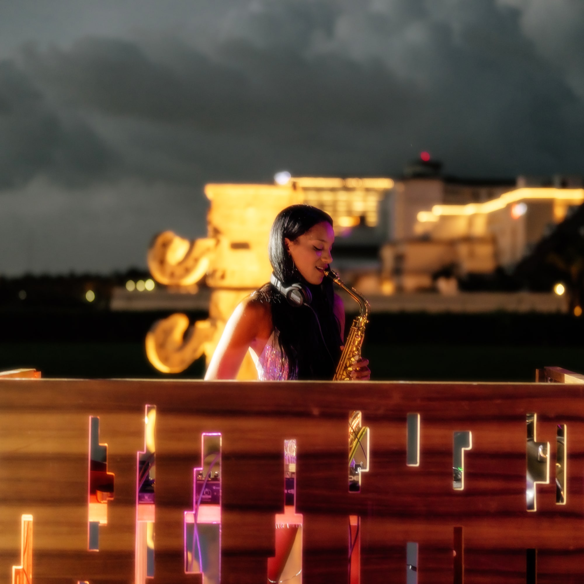 a woman playing a saxophone on a wooden fence