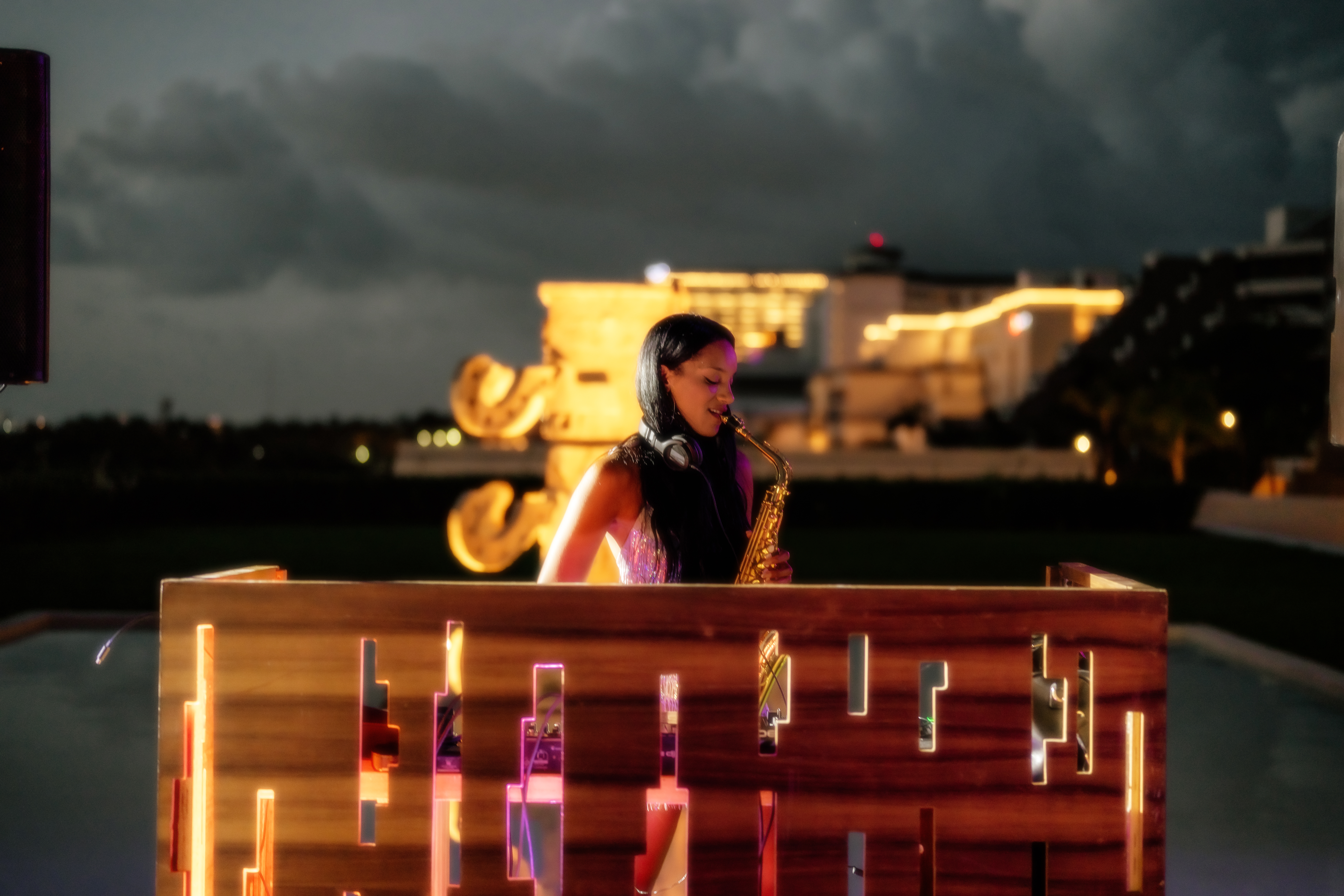 a woman playing a saxophone on a wooden fence