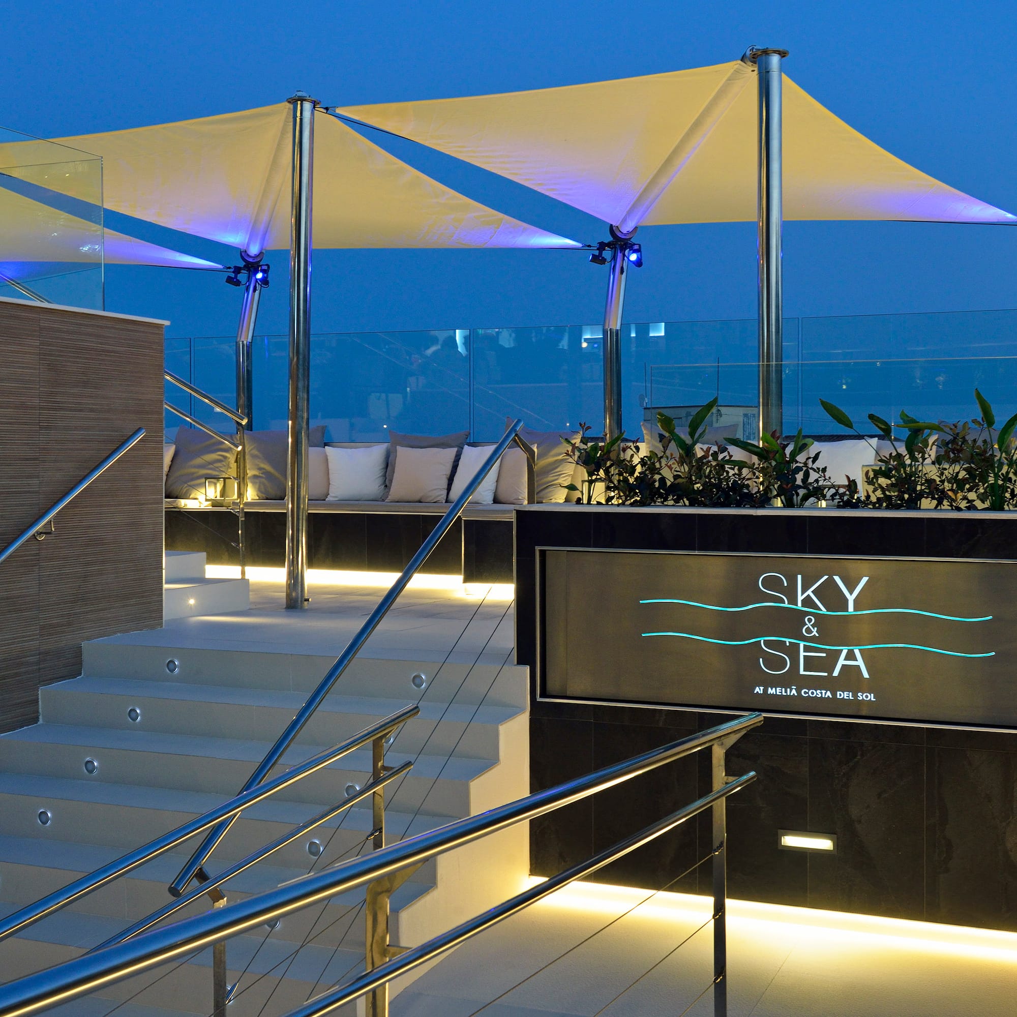 Sky & Sea rooftop bar entrance, illuminated stairs, modern canopy at dusk.