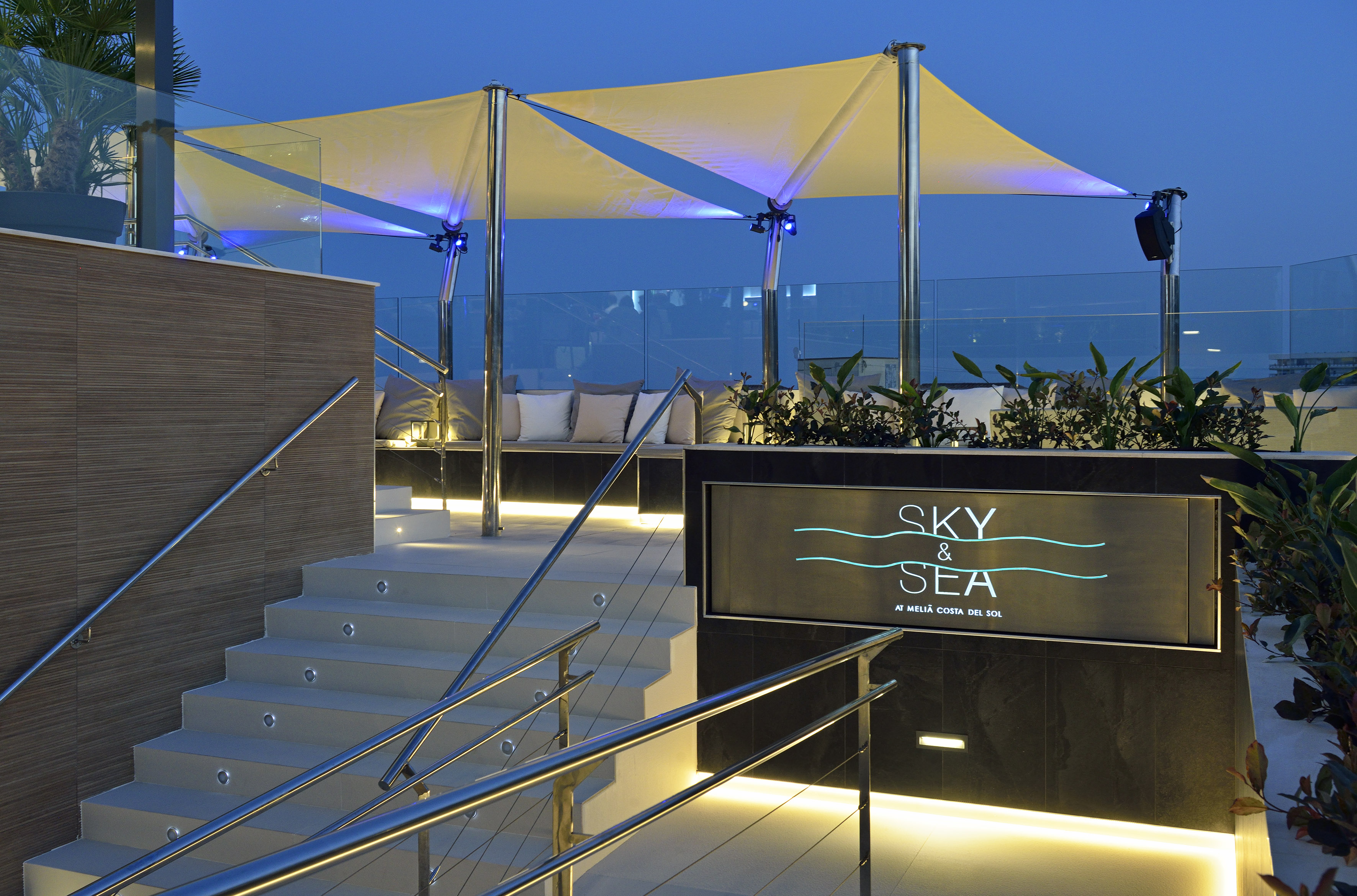 Sky & Sea rooftop bar entrance, illuminated stairs, modern canopy at dusk.