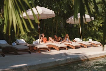 a group of people lying on lounge chairs under umbrellas