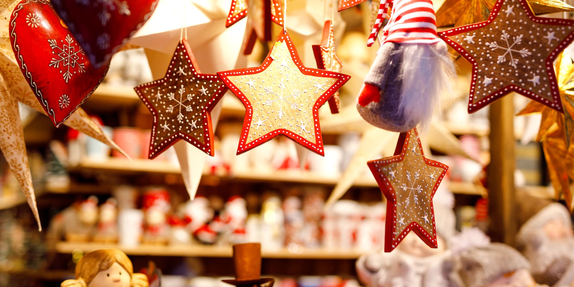 Hanging Christmas star and heart ornaments with a gnome at a holiday market.